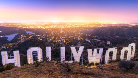 Los Angeles Hollywood jel hátulrol fotózva. A háttérben látszik Los Angeles, és a lemenő nap.