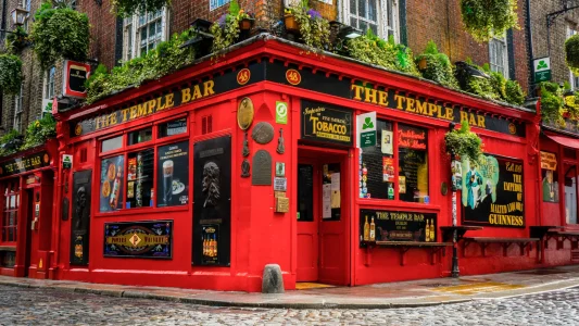 Írország, Dublin,és a legjellegzetessebb, legismertebb kocsma, pub- ja a Temple Bar. Egy sarki piros színű épület.